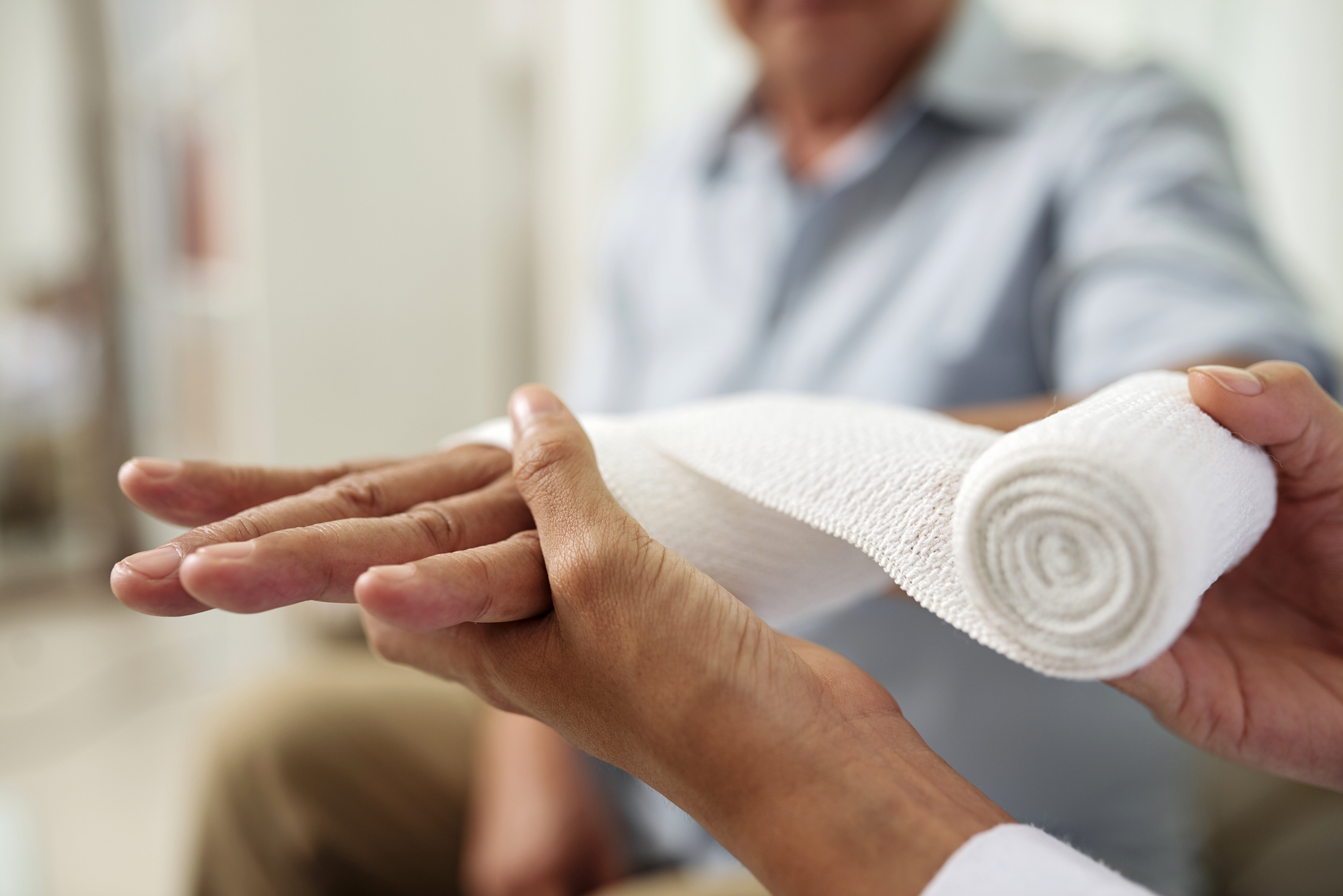 putting bandage on patient's hand